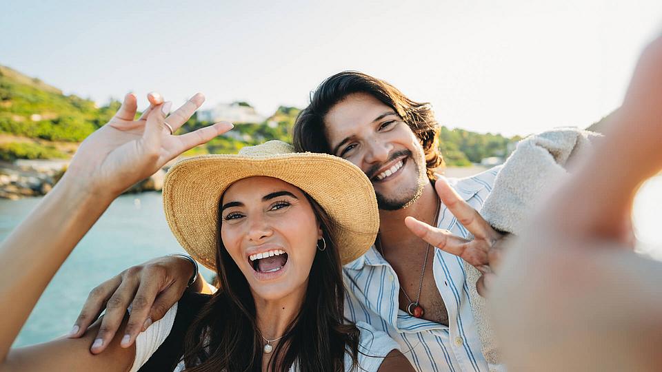 Glückliches Paar vor Meer im Urlaub