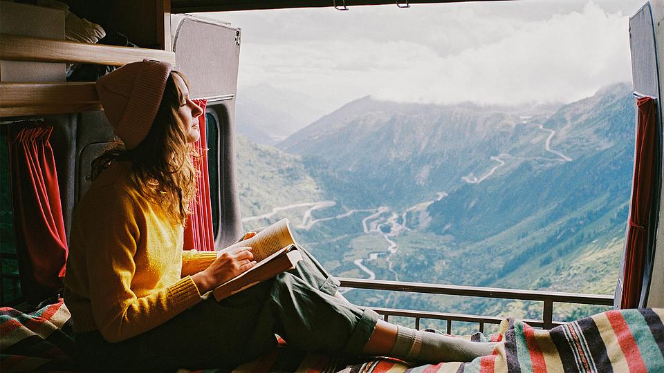 Junge Frau mit Mütze im Camper