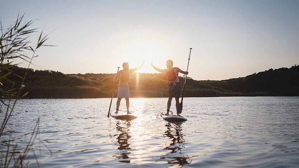 Zwei Personen auf Stand Up Paddle Boards Zwei Personen auf Stand Up Paddle Boards