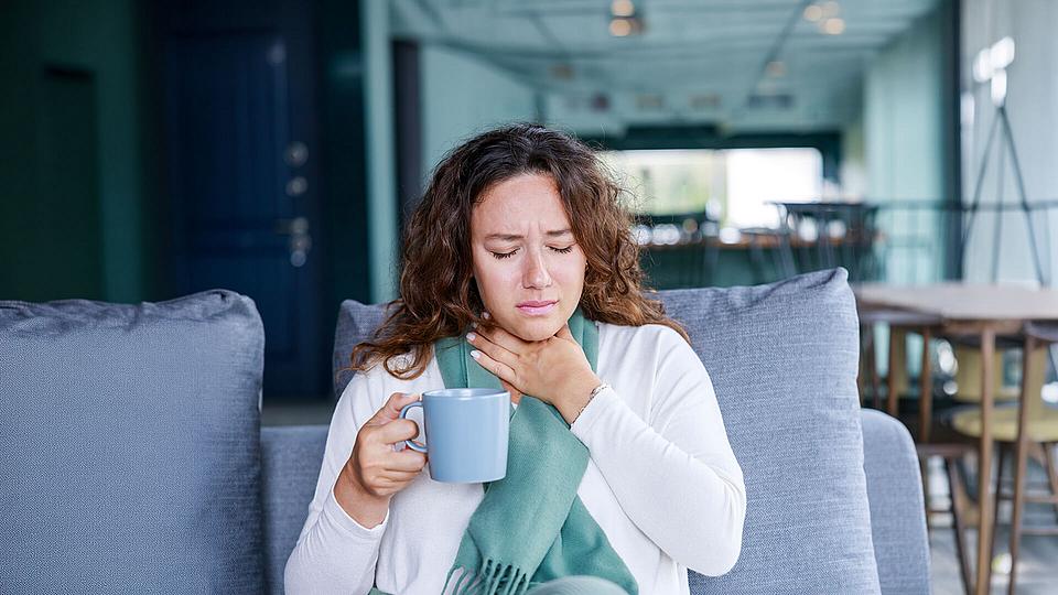 Frau mit Halsschmerzen