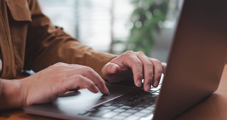 Nahaufnahme einer Person, die einen Laptop verwendet Nahaufnahme einer Person, die einen Laptop verwendet