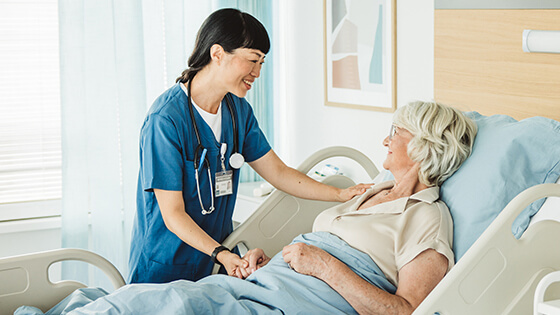 Patientin wird die Hand gehalten von einer Ärztin