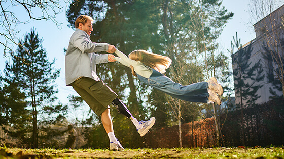 Vater spielt ausgelassen mit seinem Kind im Grünen an einem sonnigen Tag